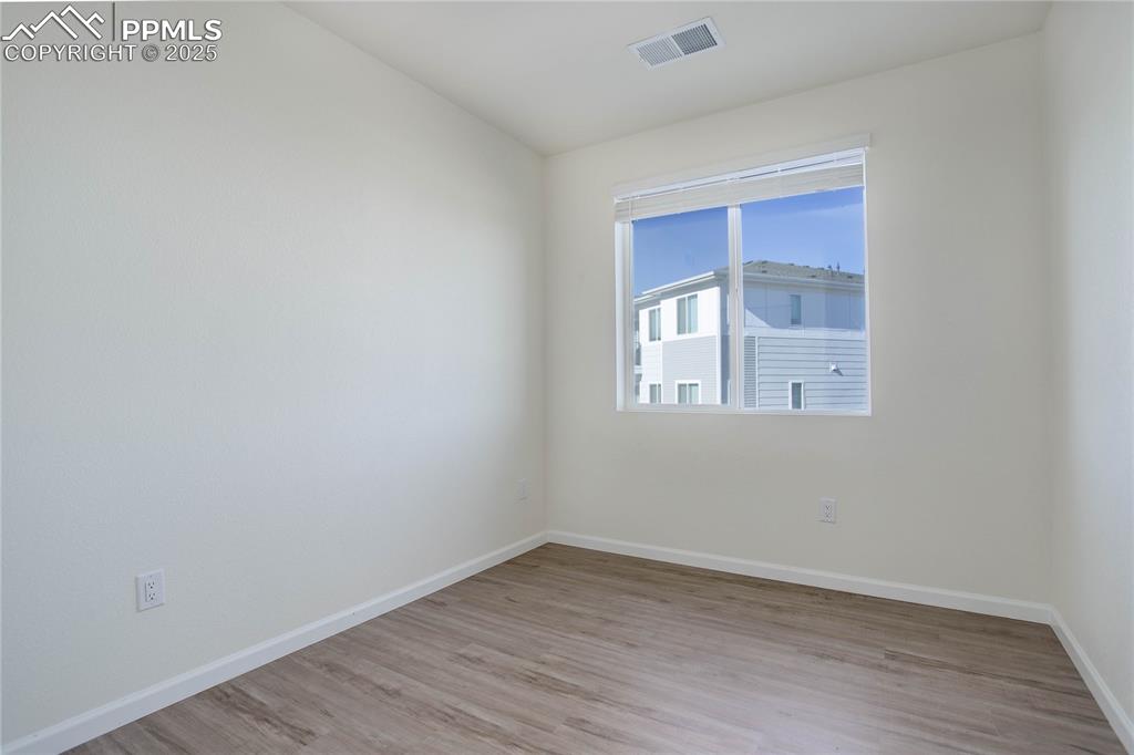3865 Presidio Point, Unit 101 Colorado Springs, CO 80920 - Photo 16 of 20 a view of an empty room with wooden floor and a window