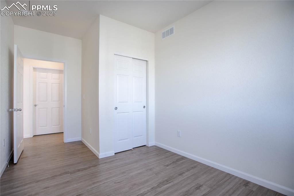 3865 Presidio Point, Unit 101 Colorado Springs, CO 80920 - Photo 17 of 20 a view of an empty room with wooden floor
