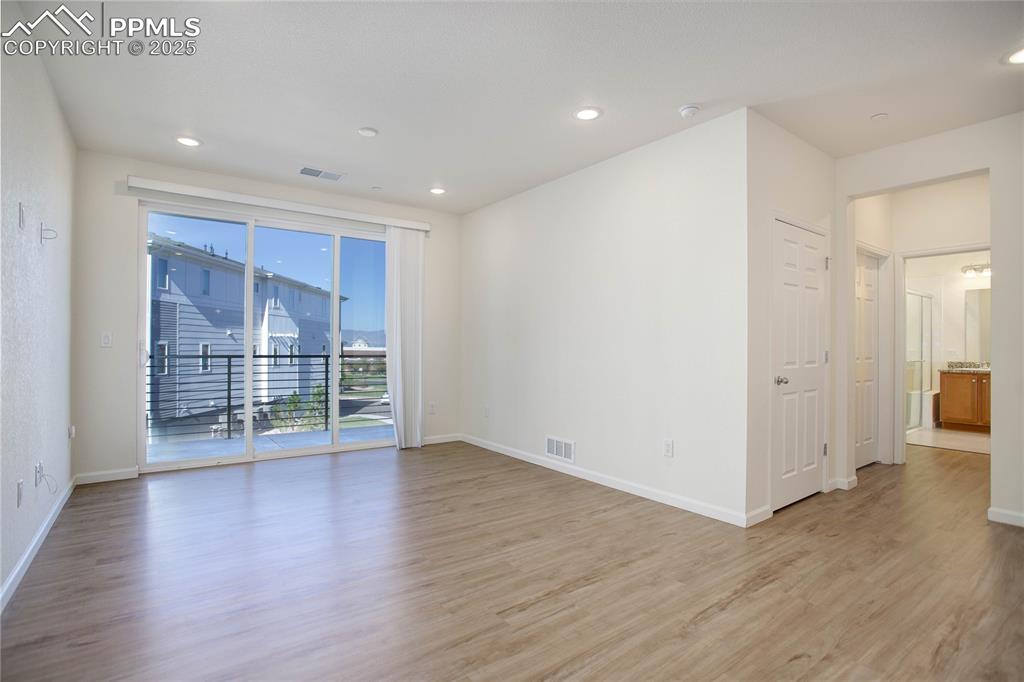 3865 Presidio Point, Unit 101 Colorado Springs, CO 80920 - Photo 7 of 20 a view of an empty room with wooden floor and a window