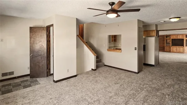a view of a livingroom with an empty space and a ceiling fan