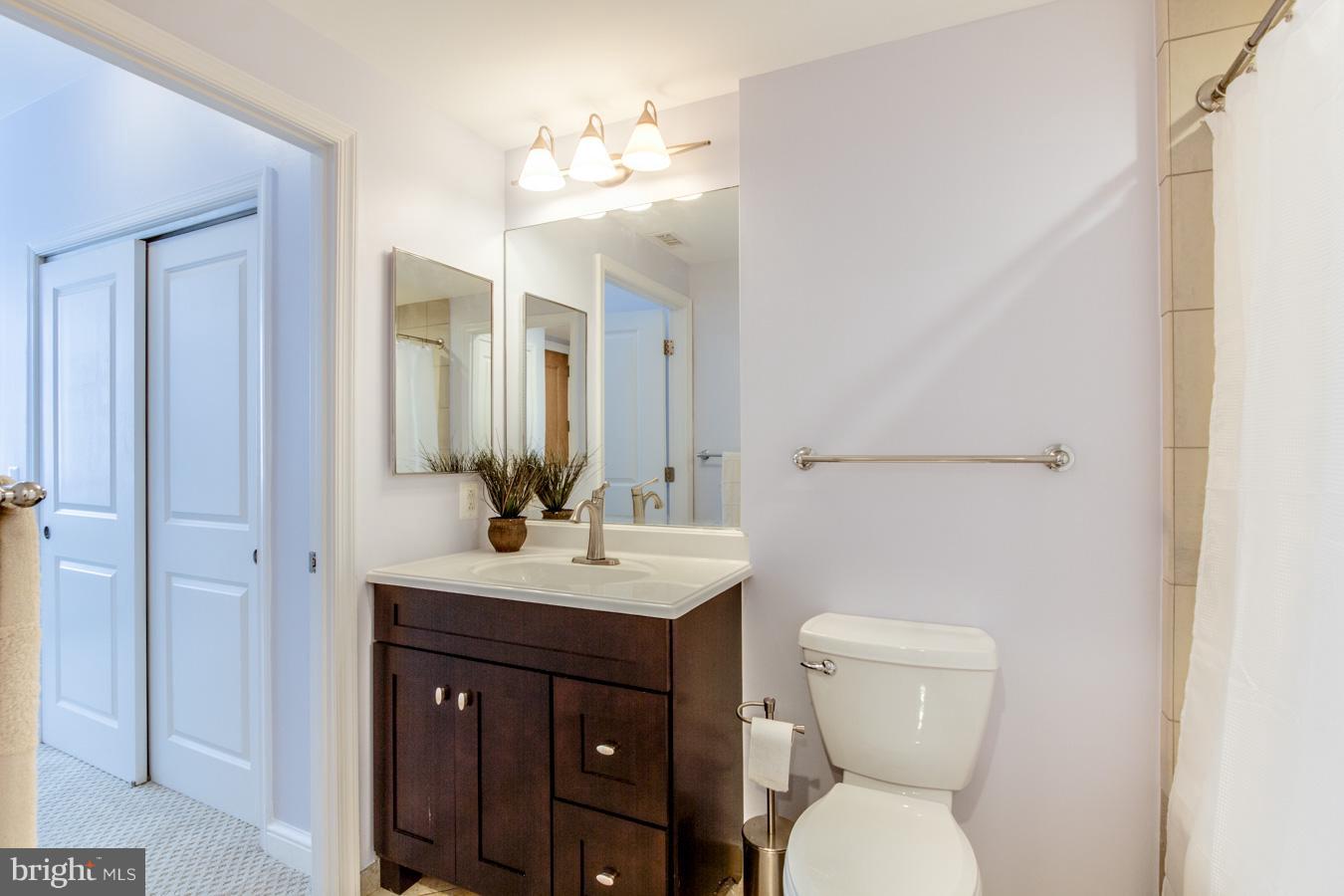 11990 Market Street, Unit 1308 Reston, VA 20190 - Photo 13 of 30 a bathroom with a toilet sink and mirror