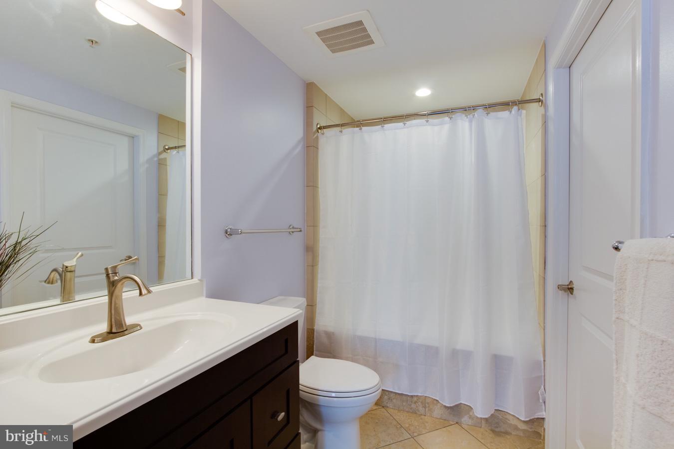 11990 Market Street, Unit 1308 Reston, VA 20190 - Photo 14 of 30 a bathroom with a sink toilet a mirror and vanity