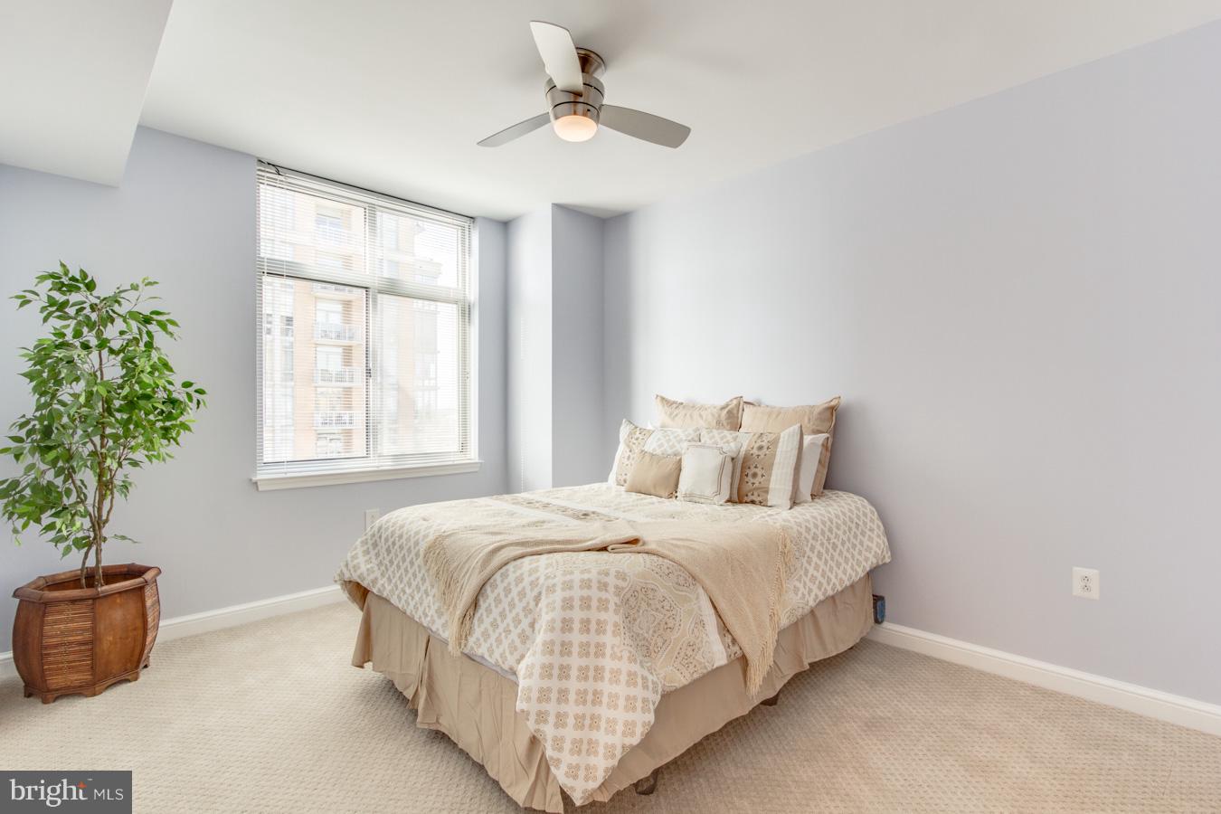 11990 Market Street, Unit 1308 Reston, VA 20190 - Photo 15 of 30 a bedroom with a bed and a potted plant