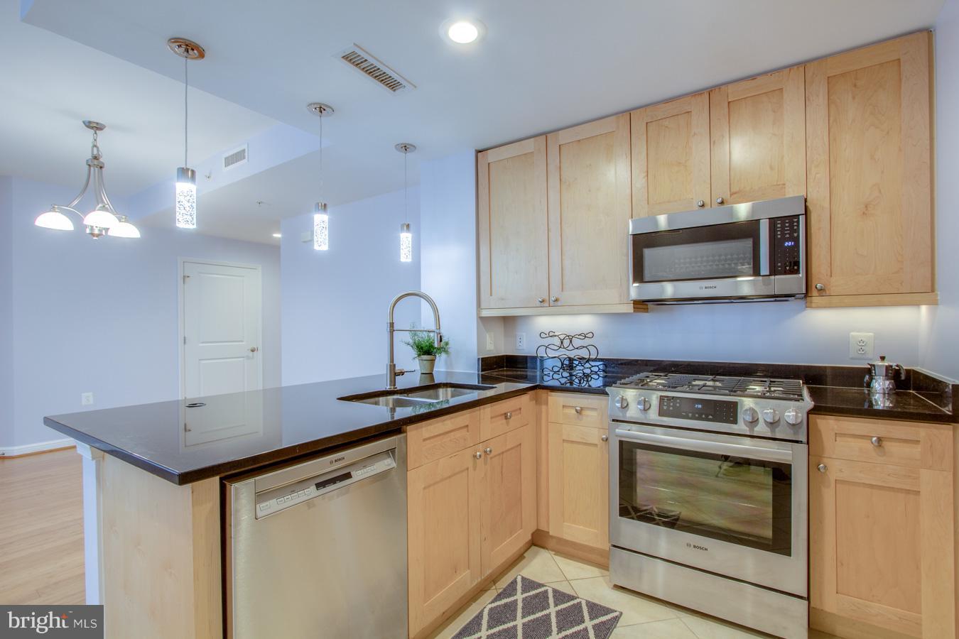 11990 Market Street, Unit 1308 Reston, VA 20190 - Photo 4 of 30 a kitchen with a sink stove and microwave