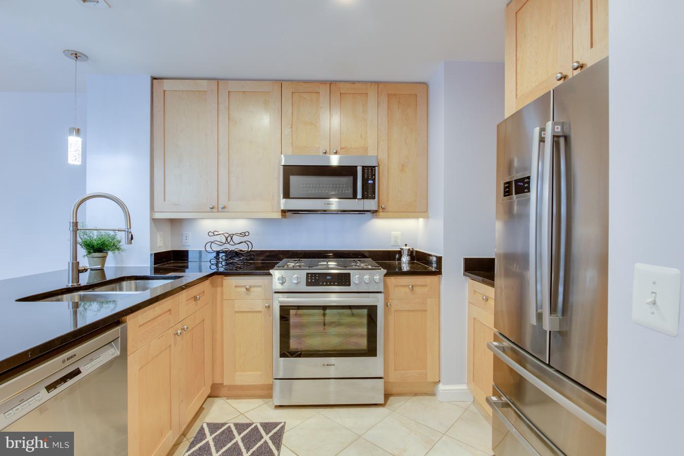 11990 Market Street, Unit 1308 Reston, VA 20190 - Photo 5 of 30 a kitchen with a stove microwave and refrigerator