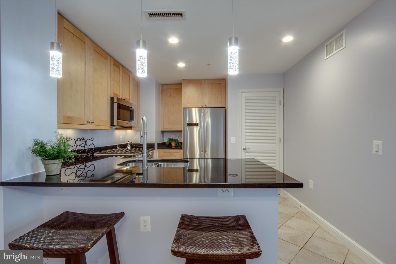 11990 Market Street, Unit 1308 Reston, VA 20190 - Photo 7 of 30 a kitchen with stainless steel appliances granite countertop a refrigerator and a stove