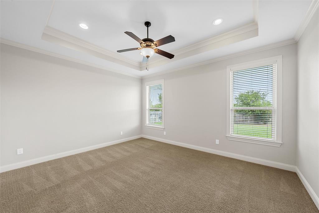 144 Ellis Farm Road Hewitt, TX 76643 - Photo 23 of 36 Spacious interior room featuring a tray ceiling with recessed lighting and a ceiling fan, two large windows with blinds, light-colored walls, and textured carpeting