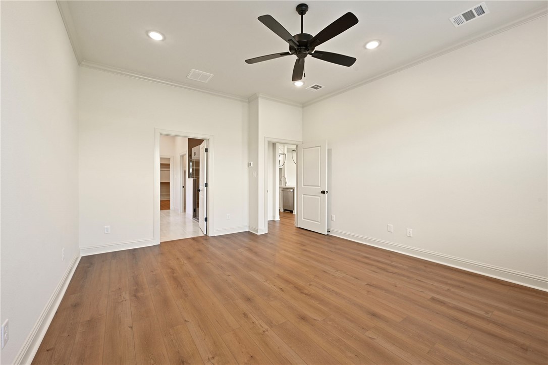7052 Skipping Rock Path Bryan, TX 77808 - Photo 11 of 23 a view of a big room with wooden floor and a ceiling fan