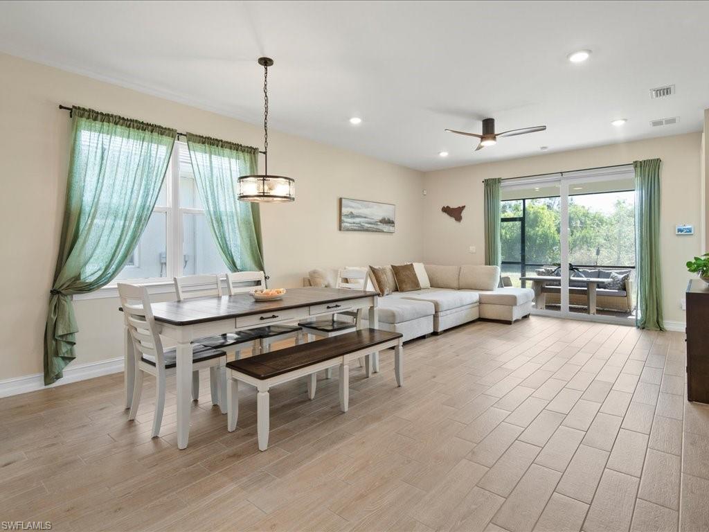 1046 Enbrook Loop Naples, FL 34114 - Photo 5 of 43 Dining area featuring ceiling fan with notable chandelier and light wood-type flooring