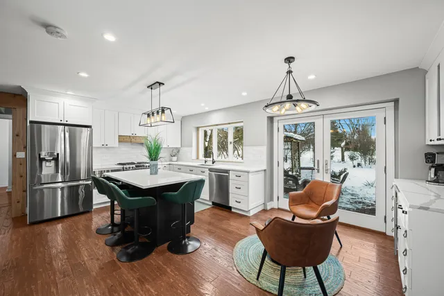 a dining room with furniture a chandelier and wooden floor