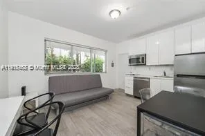 a living room with furniture and a kitchen