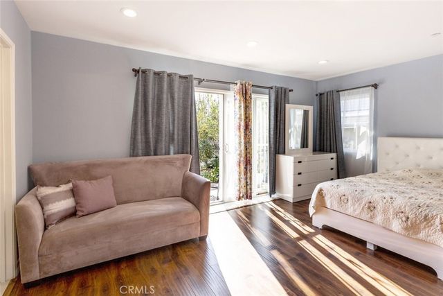 a bedroom with a bed couch and a large window