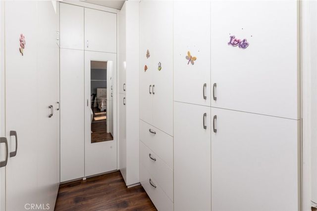 a view of a hallway with wooden floor and closet