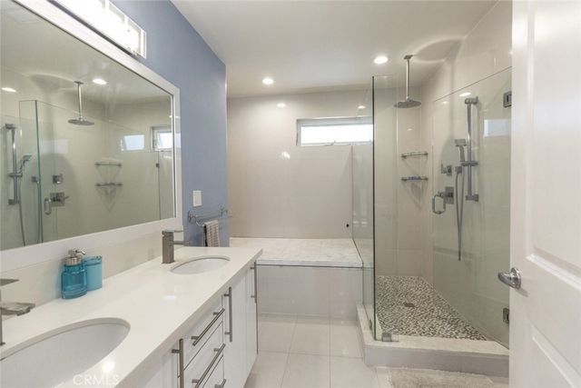 a bathroom with a granite countertop sink mirror and shower