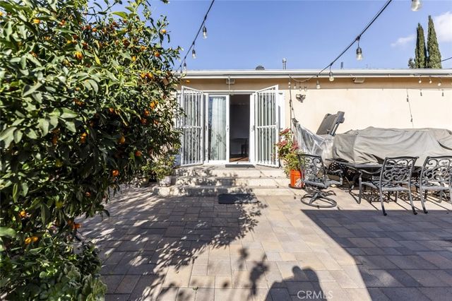 a view of a patio with table and chairs near a yard