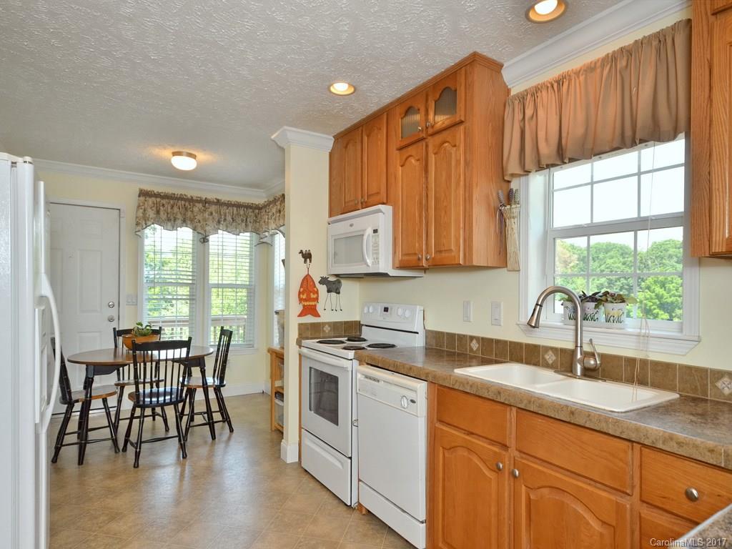 141 Ingram Loop Clyde, NC 28721 - Photo 5 of 16 a kitchen with stainless steel appliances granite countertop a stove a sink a microwave a dining table and chairs