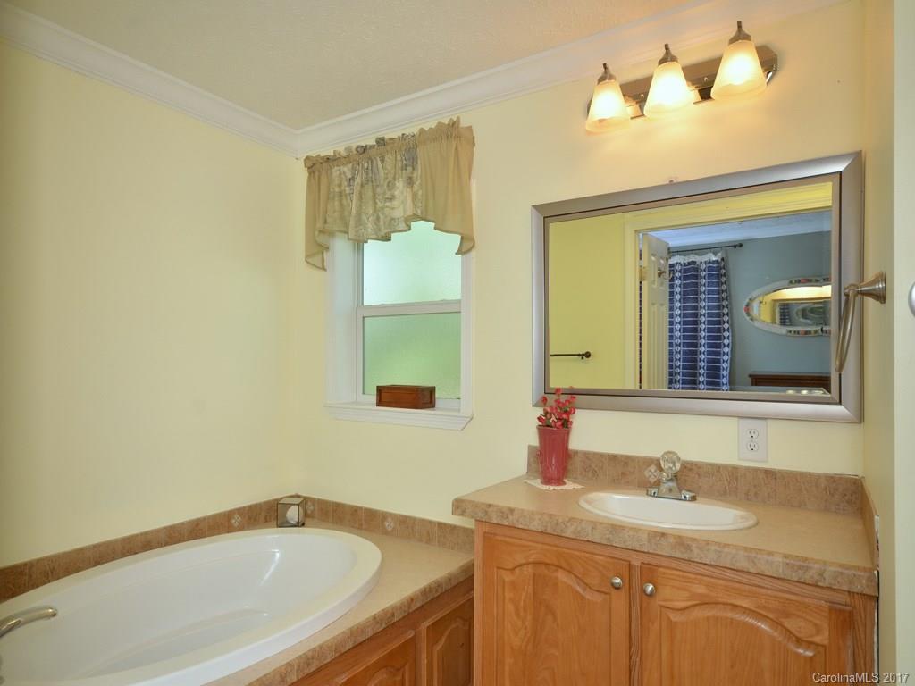141 Ingram Loop Clyde, NC 28721 - Photo 10 of 16 a bathroom with a granite countertop sink and a mirror