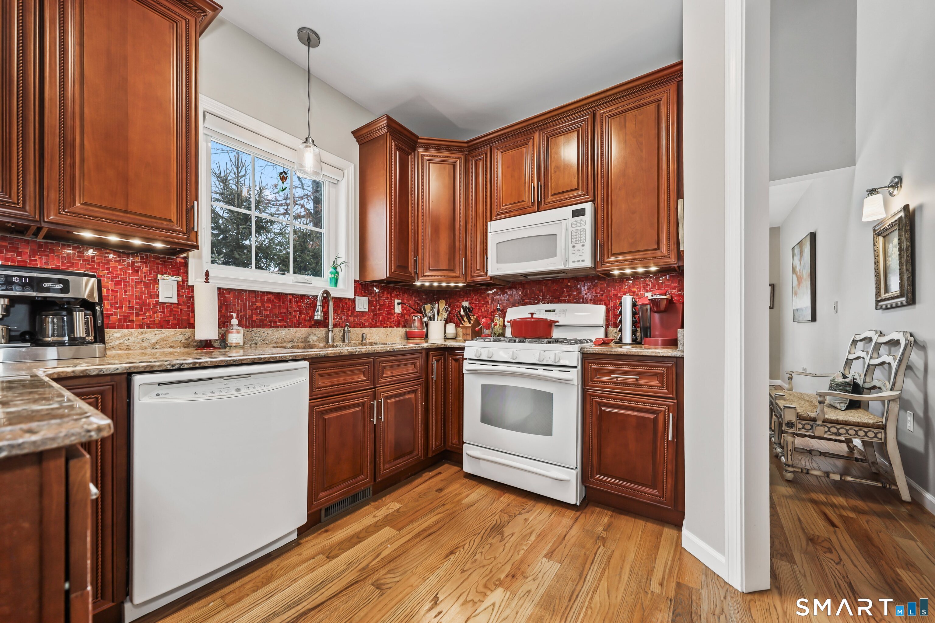 101 Turtlebrook Lane, Unit 101 Bristol, CT 06010 - Photo 17 of 48 a kitchen with stainless steel appliances granite countertop wooden cabinets a sink and dishwasher with wooden floor