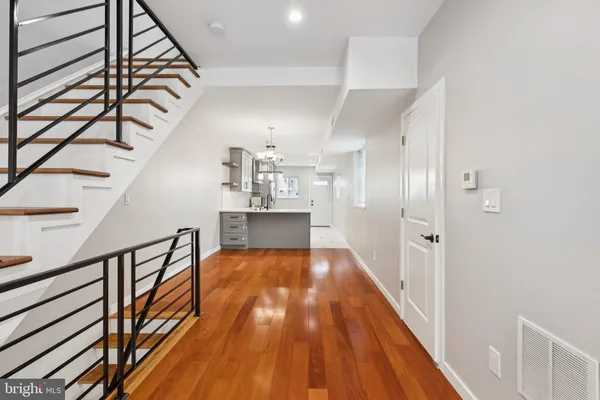 a view of a hallway with wooden floor and staircase