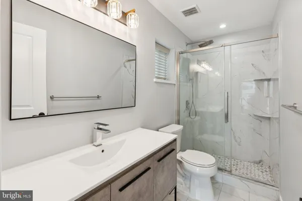 a bathroom with a sink toilet a mirror and shower