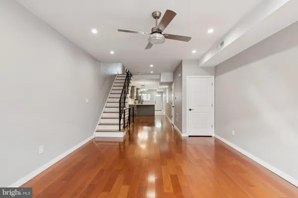 a view of a hallway with wooden floor and staircase