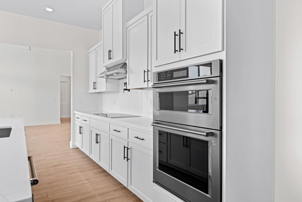 14854 Grace Warren Way Rancho Murieta, CA 95683 - Photo 14 of 27 a kitchen with granite countertop white cabinets and stainless steel appliances