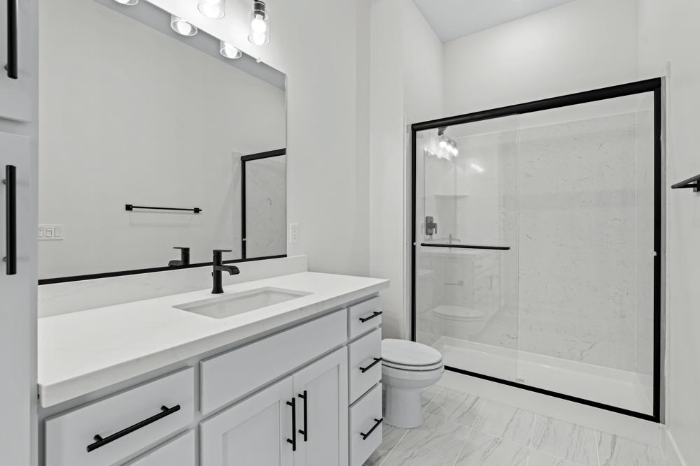 14854 Grace Warren Way Rancho Murieta, CA 95683 - Photo 20 of 27 a bathroom with a sink a toilet a mirror and shower