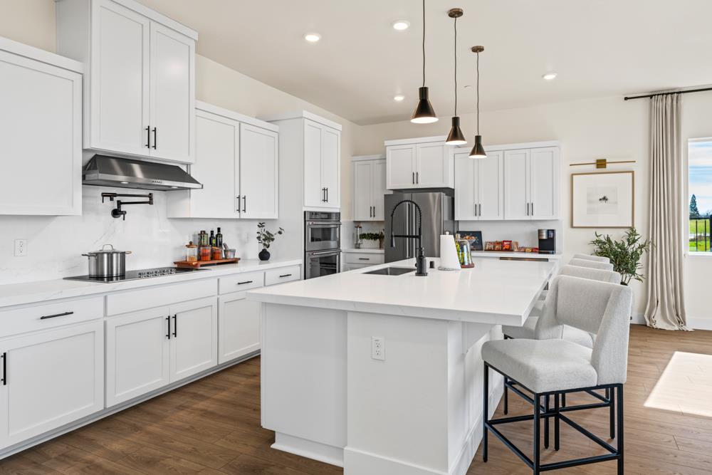 14854 Grace Warren Way Rancho Murieta, CA 95683 - Photo 8 of 27 a kitchen with stainless steel appliances and white cabinets