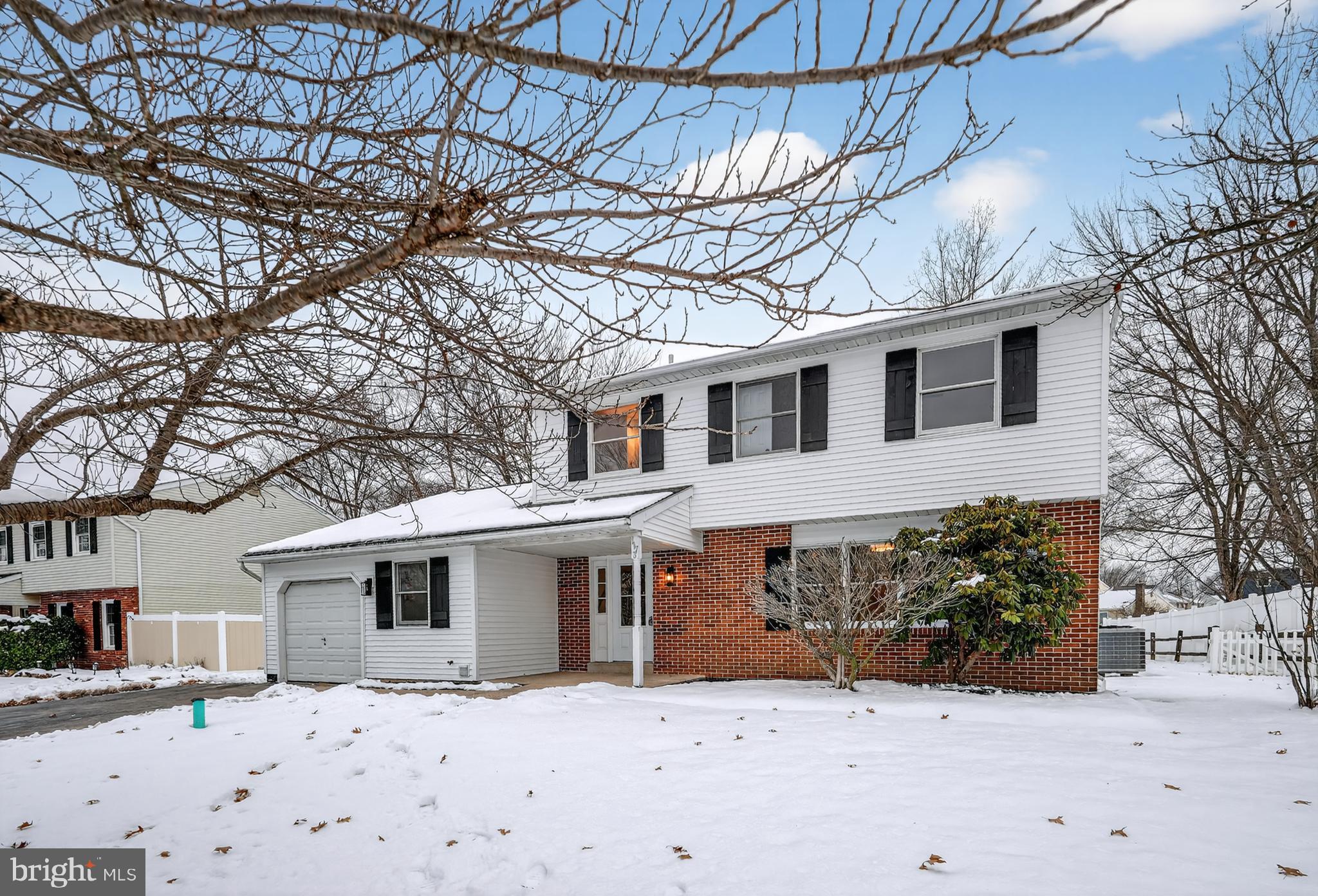 a front view of a house with a yard covered in snow