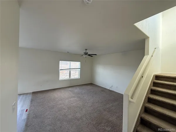 an empty room with windows and stairs