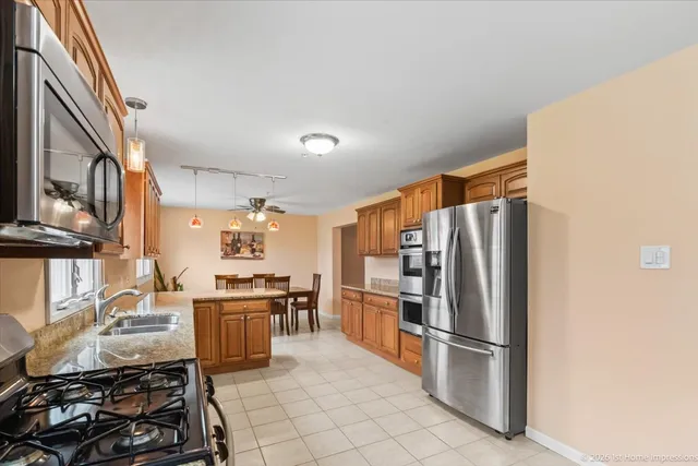 a kitchen with granite countertop a refrigerator stove and sink