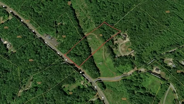 an aerial view of residential house with outdoor space and trees all around