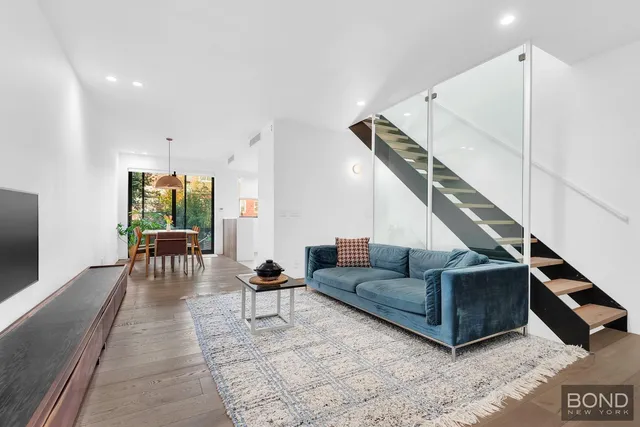 a living room with furniture and a dining table with wooden floor