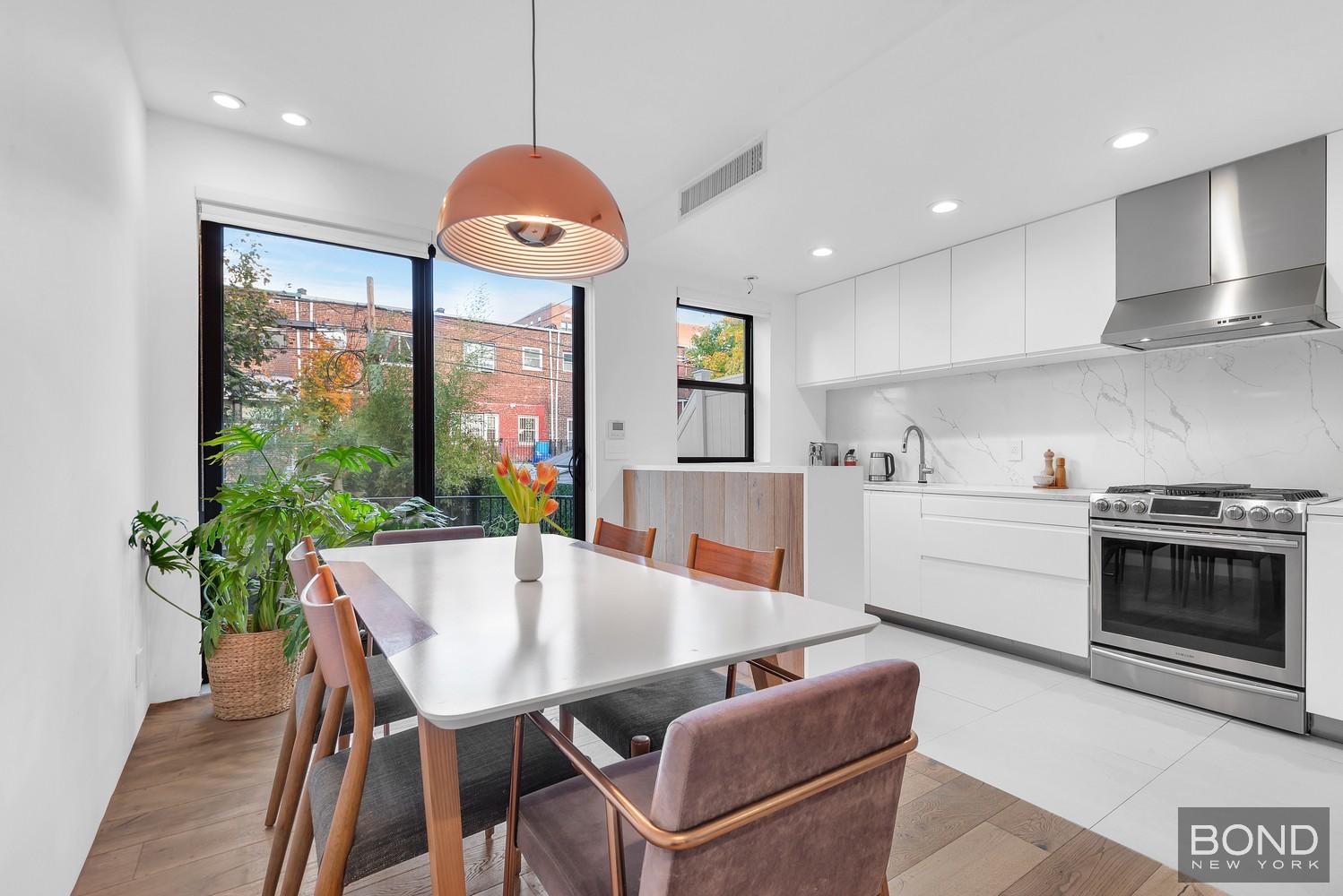 103 Remsen Avenue Brooklyn, NY 11212 - Photo 2 of 11 a kitchen with stainless steel appliances granite countertop a stove a refrigerator a kitchen island with a dining table and chairs