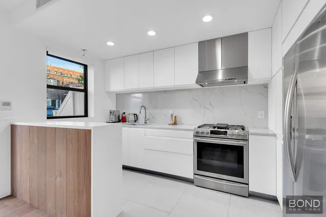 a kitchen with stainless steel appliances granite countertop a stove a sink and a refrigerator