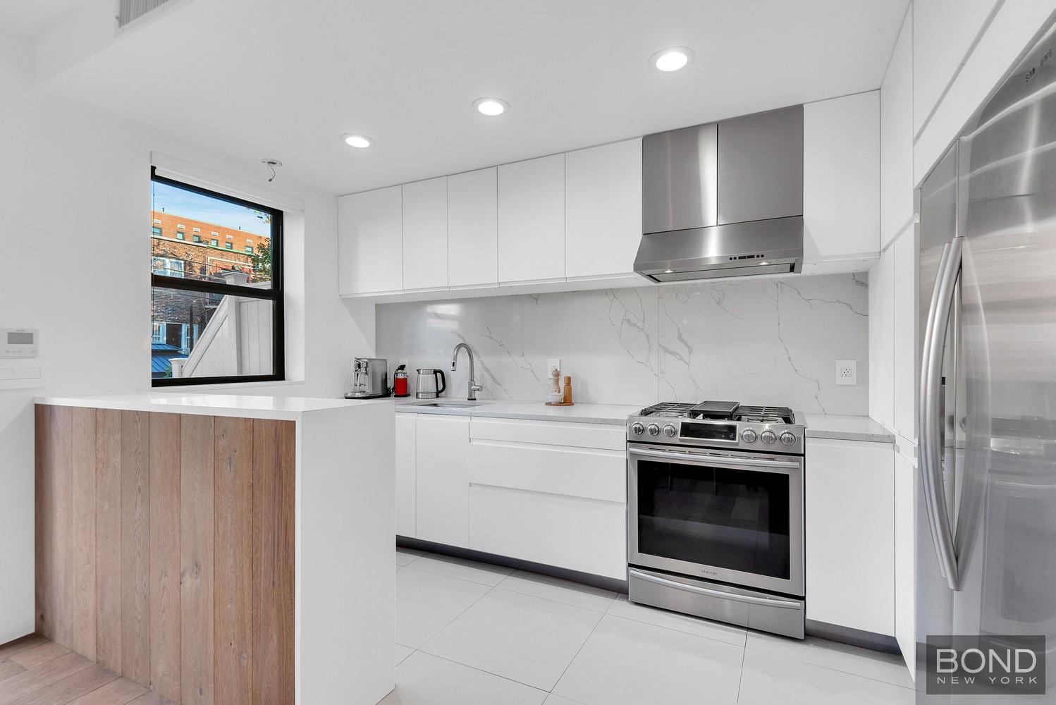 103 Remsen Avenue Brooklyn, NY 11212 - Photo 3 of 11 a kitchen with stainless steel appliances granite countertop a stove a sink and a refrigerator