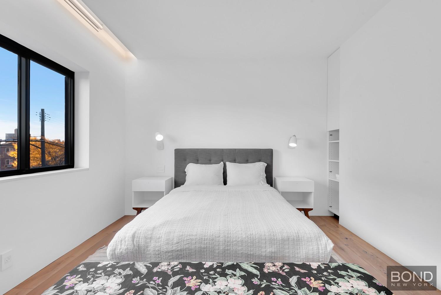 103 Remsen Avenue Brooklyn, NY 11212 - Photo 8 of 11 a large bed sitting in a bedroom next to a window