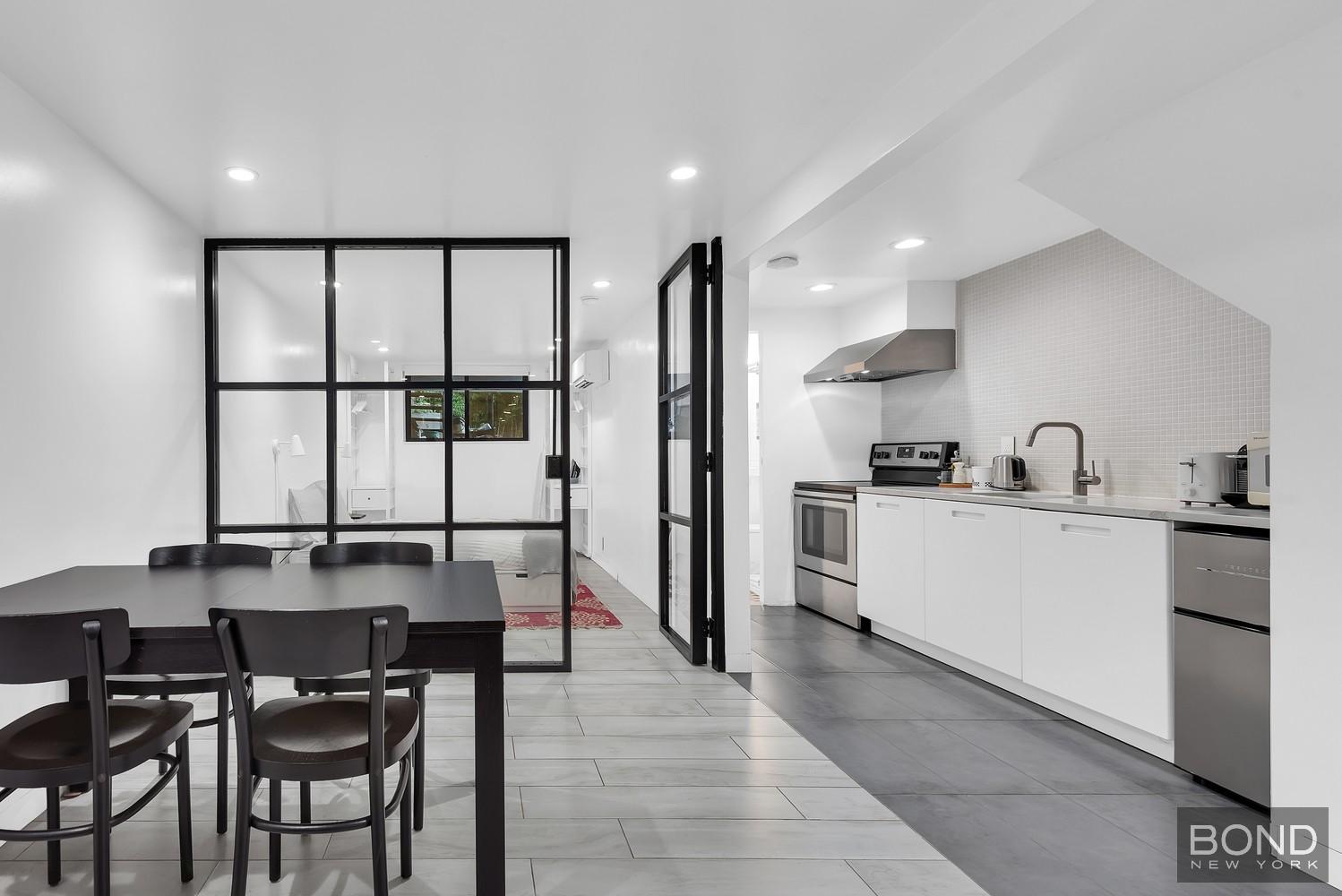 103 Remsen Avenue Brooklyn, NY 11212 - Photo 9 of 11 a kitchen with stainless steel appliances kitchen island granite countertop a sink and cabinets
