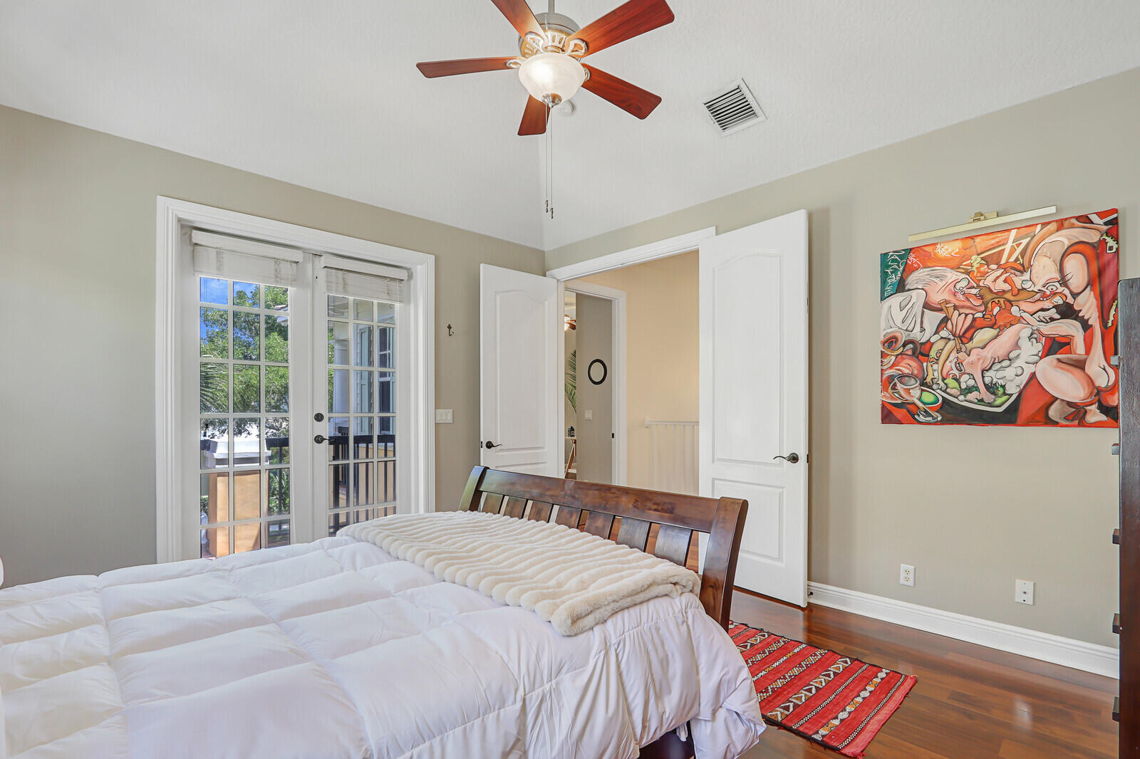 122 Inkberry Drive Jupiter, FL 33458 - Photo 23 of 56 a bedroom with a bed and a chandelier