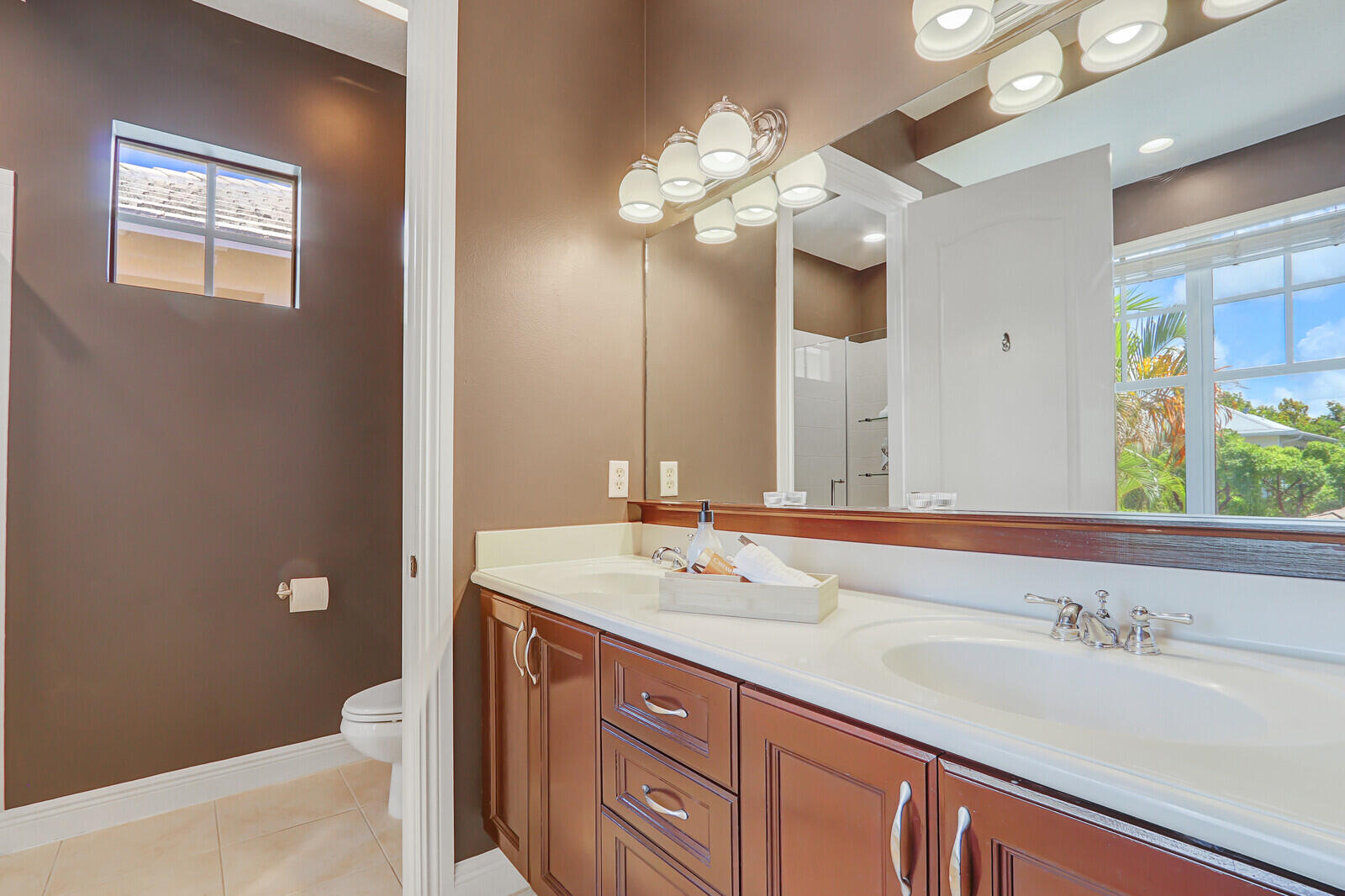 122 Inkberry Drive Jupiter, FL 33458 - Photo 27 of 56 a bathroom with a sink a large mirror and a light fixture