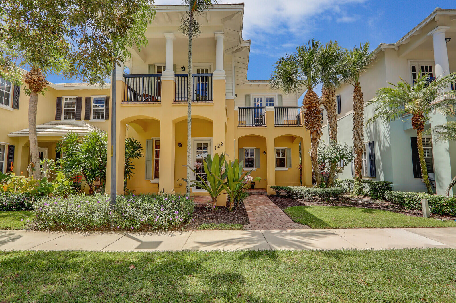 122 Inkberry Drive Jupiter, FL 33458 - Photo 3 of 56 a front view of a multi story residential apartment building with yard and green space