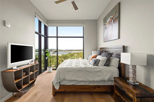 a bedroom with a bed and a flat tv screen next to a window