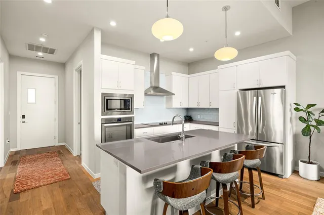 a kitchen with granite countertop a sink stove and refrigerator