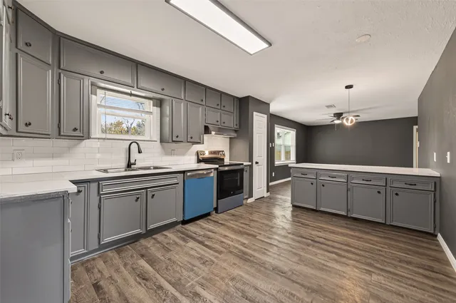 a kitchen with kitchen island granite countertop a sink cabinets and stainless steel appliances
