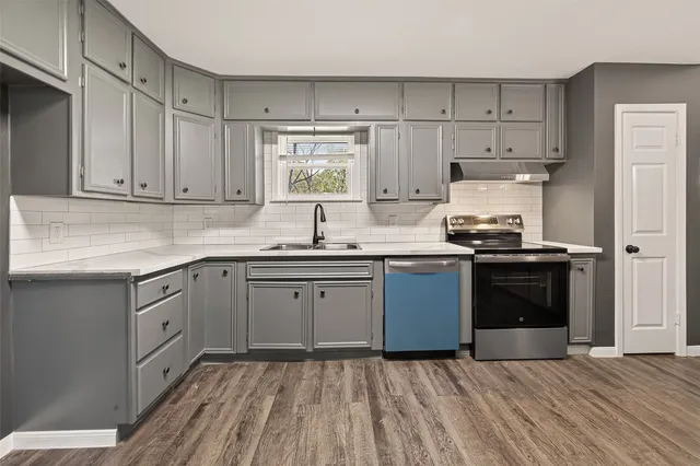 a kitchen with stainless steel appliances granite countertop a stove a sink and a refrigerator