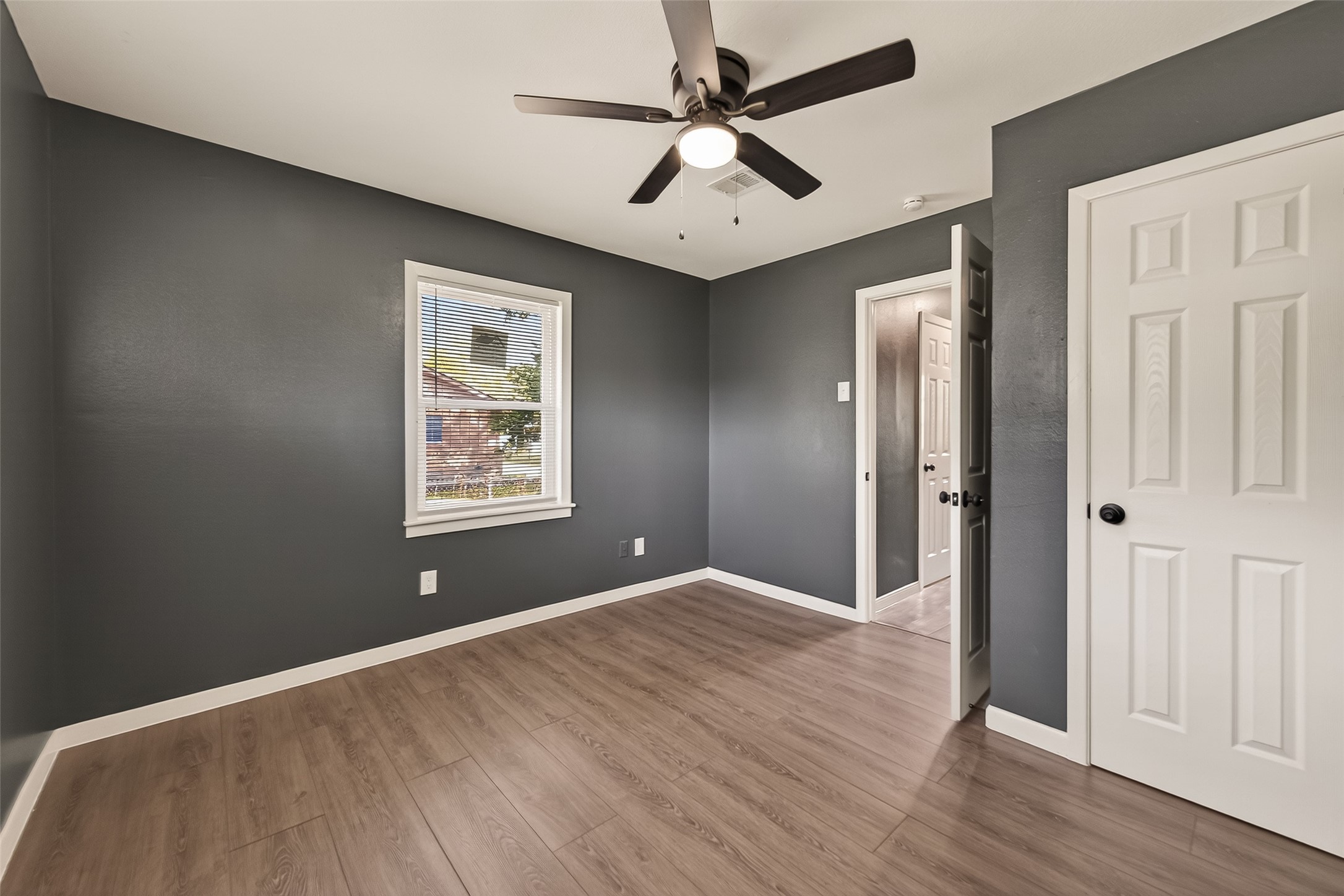 2619 Sinclair Street Pasadena, TX 77503 - Photo 16 of 29 an empty room with wooden floor ceiling fan and windows