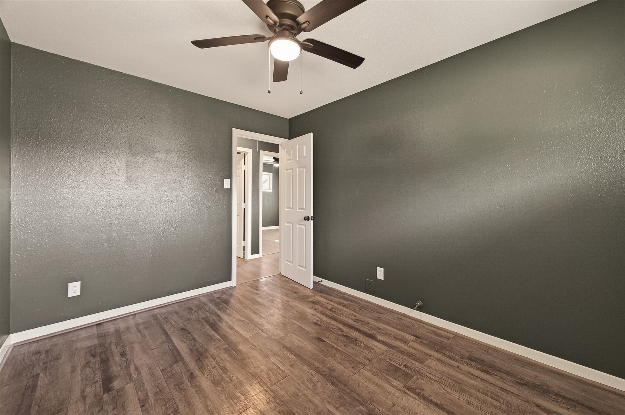2619 Sinclair Street Pasadena, TX 77503 - Photo 18 of 29 wooden floor in an empty room with a chandelier fan