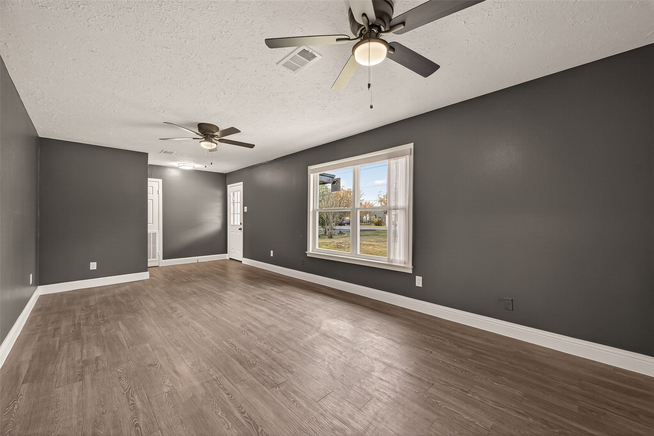 2619 Sinclair Street Pasadena, TX 77503 - Photo 6 of 29 a view of an empty room with a window and wooden floor