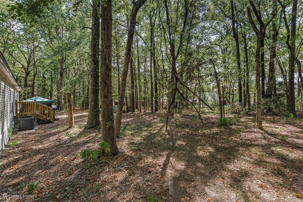 8273 Godfrey Road Shreveport, LA 71129 - Photo 27 of 27 Expansive wooded property featuring mature trees and a wooden deck with railing