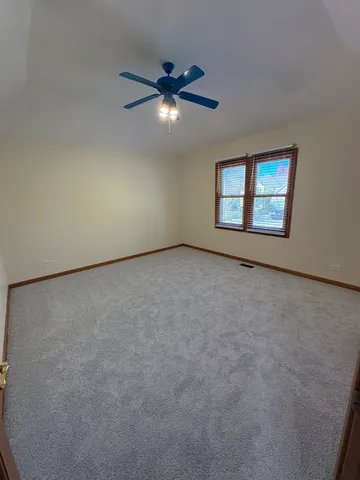 an empty room with windows and ceiling fan view